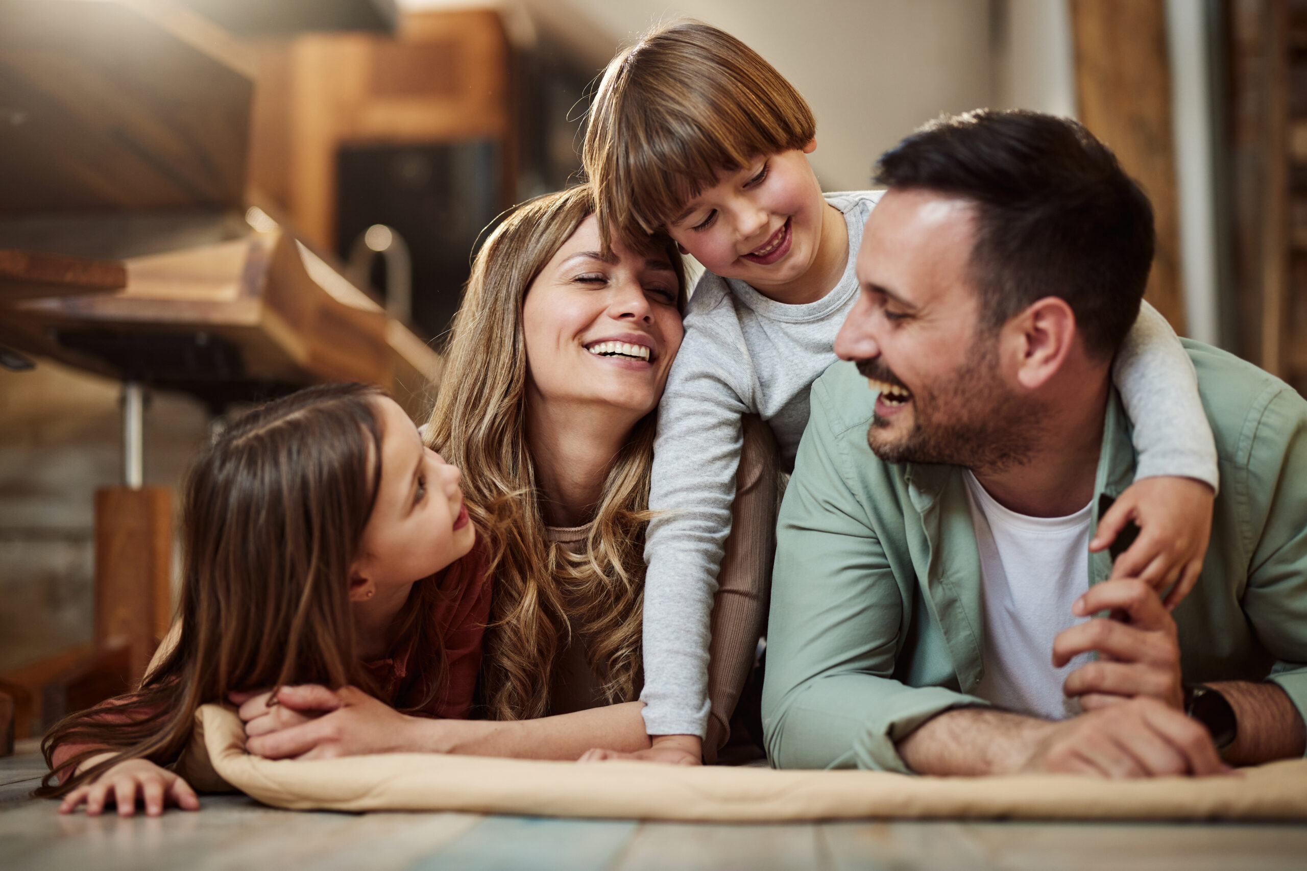 Young happy family talking on blanket at home.